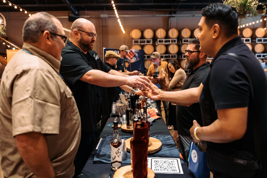 Attendees smelling and tasting pours at a festival tasting table