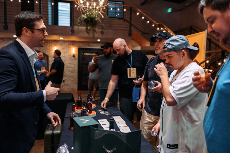 A festival guest holding a bottle of Kentucky sour mash whiskey