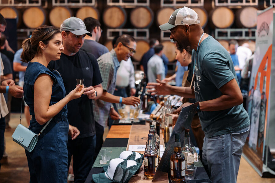 Two vendor representatives posing with bottles at their festival booth