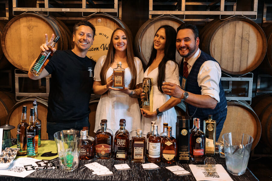An attendee smiling and holding a bottle for a photo at the festival