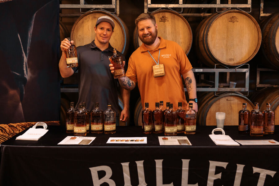 Attendees sampling pours at a bourbon and rye whiskey booth