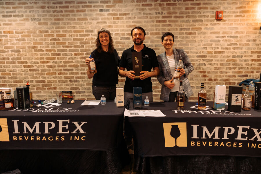 Attendees gathered around a tasting table sampling whisk(e)y expressions