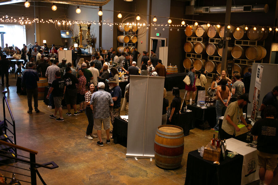 A distiller pouring whisk(e)y samples for a group of attendees
