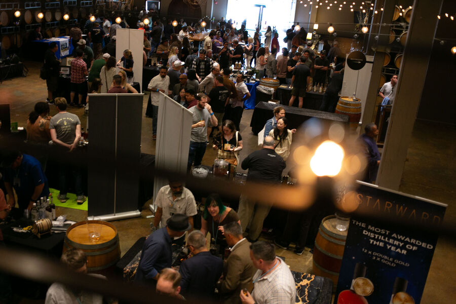 Attendees sampling whisk(e)y near the festival's live music stage
